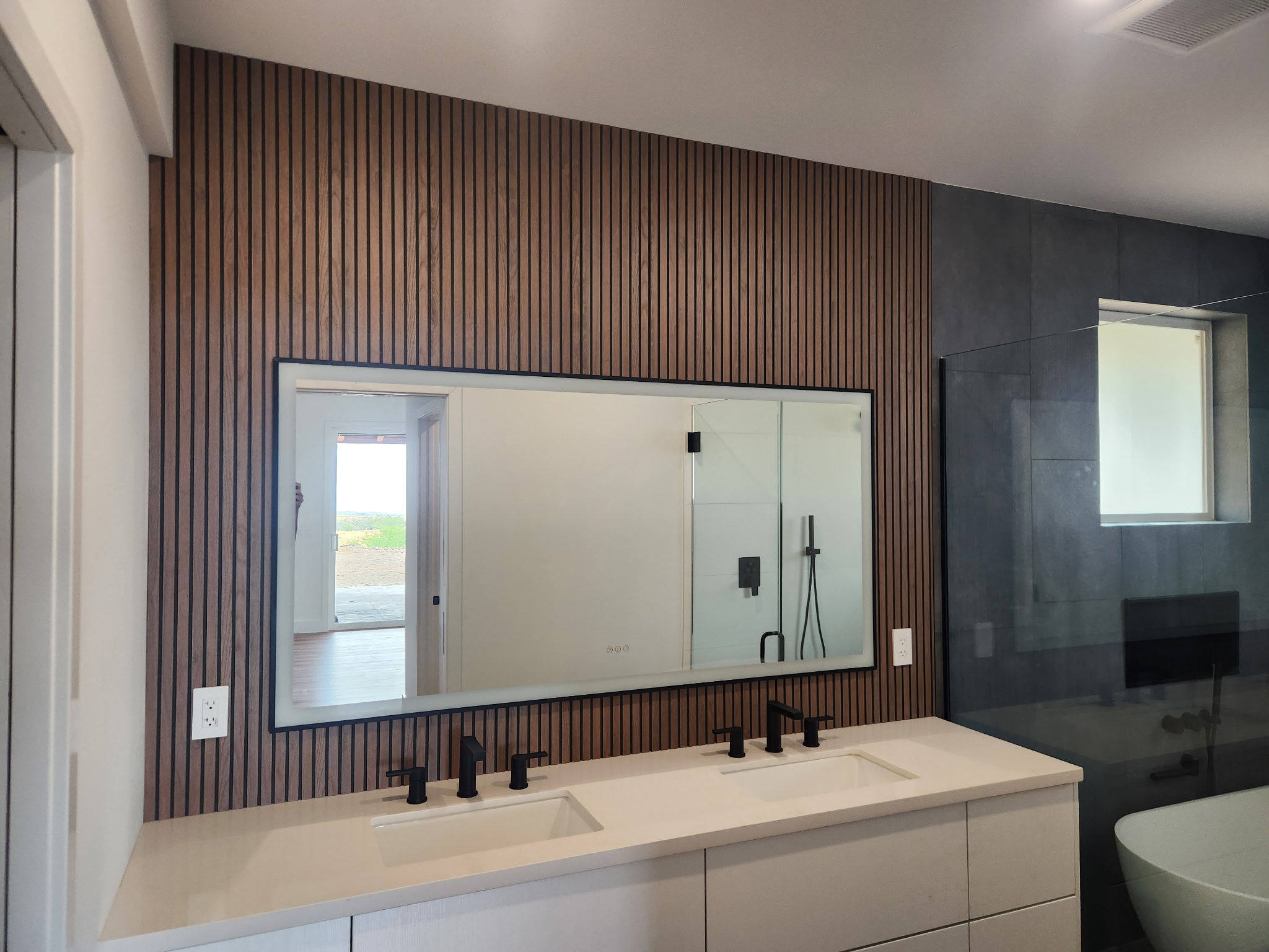 Master bath with walnut slat wall and freestanding tub
